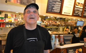 A Woods resident smiles during his shift at Corner Bakery Cafe.